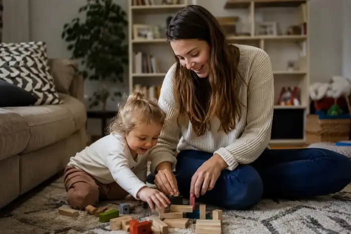 Calm parent and children playing with wooden blocks together